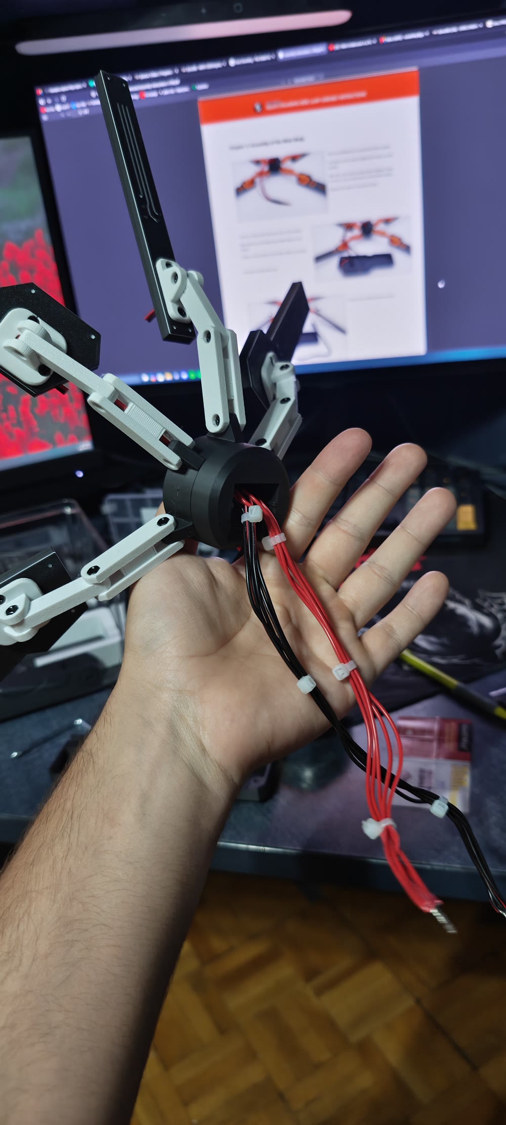 Back of the assembled lamp hub resting in a hand, with red and black wires bundled by zip ties