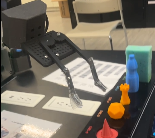 Q-Arm gripper prototype holding a set of small printed objects