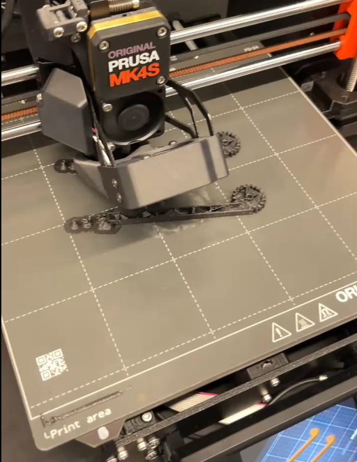 3D printer producing a gripper part mid-print