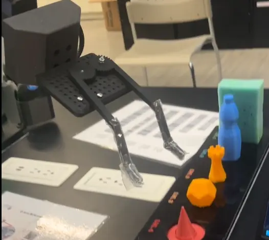 Q-Arm gripper holding small printed objects
